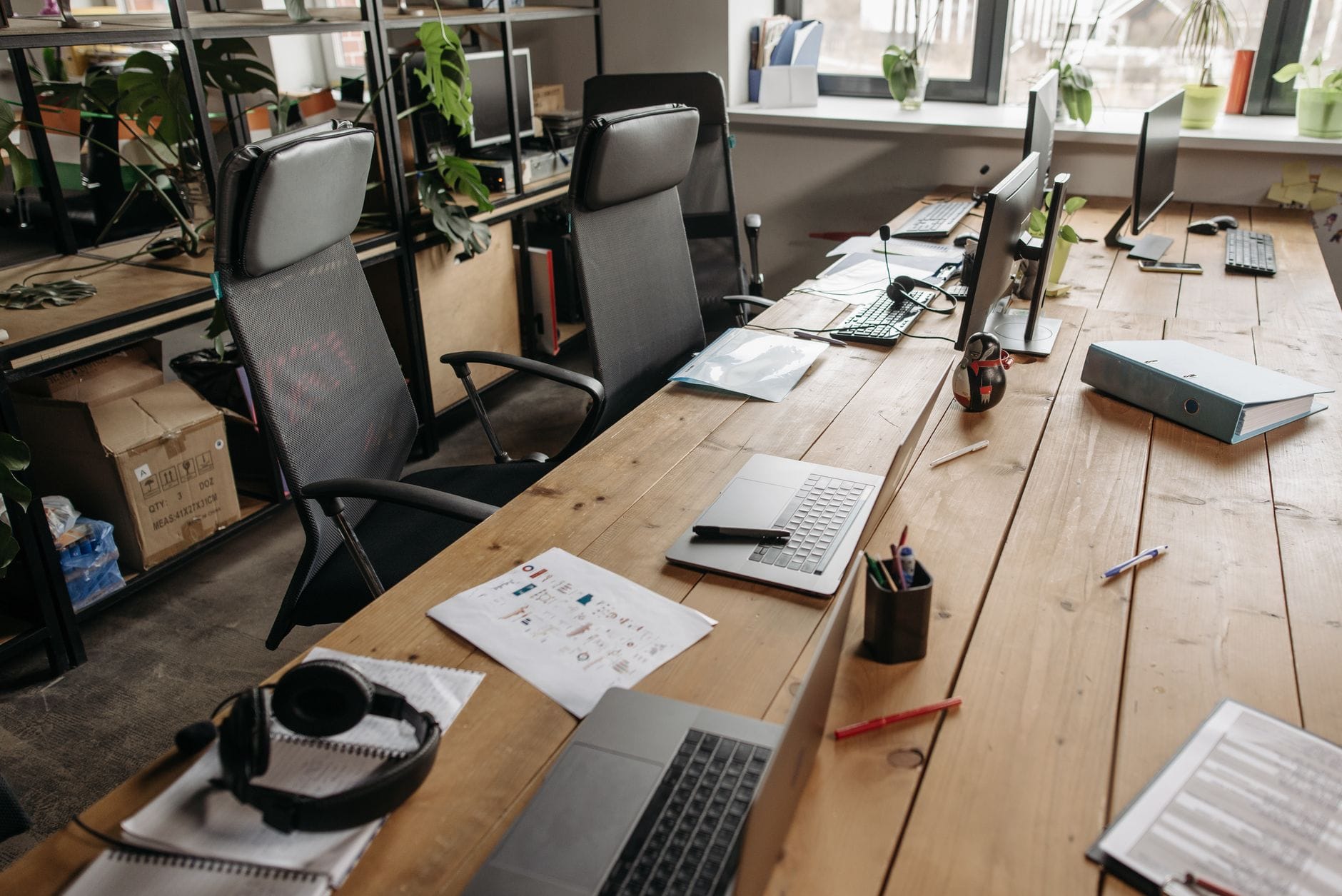 Przestronne biuro coworkingowe z drewnianymi biurkami i laptopami